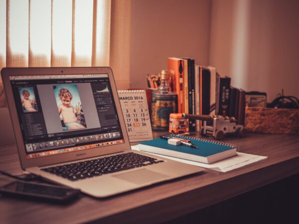 turned on screen silver macbook air on wooden desk